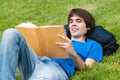 Guy laying on the grass and reading a book Royalty Free Stock Photo