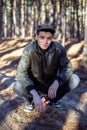 A guy in a leather jacket and cap sits on a road in a forest Royalty Free Stock Photo