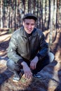 A guy in a leather jacket and cap sits on a road in a forest Royalty Free Stock Photo