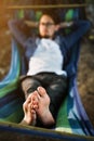 man resting in a hammock in nature. man in blue shirt  on vacation Royalty Free Stock Photo