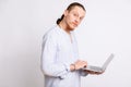 A guy in a light blue shirt holding a laptop in his hands, looking at the camera. Royalty Free Stock Photo