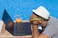 Guy looking at laptop screen at the poolside Royalty Free Stock Photo