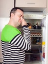 Guy looking for something in pan near fridge Royalty Free Stock Photo