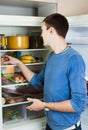 Guy looking for something in pan near fridge Royalty Free Stock Photo