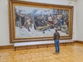 The guy looks at the painting by Surikov \