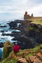 Guy looks at the rocks of Londrangar in Iceland