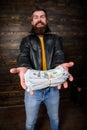 Guy mafia dealer with cash profit. Man brutal bearded hipster wear leather jacket and hold cash money. Man give cash Royalty Free Stock Photo