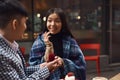 Guy makes a wedding proposal to girl sitting at table in cafe.