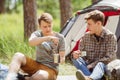 A guy making himself tea while talking to his friend