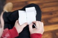 Guy making notes on a small diary while sitting relaxed in a wooden floored room.