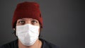 Guy in a medical white mask on a dark background copy space.  respiratory viral covid-19 quarantine pandemic Royalty Free Stock Photo