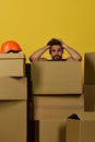 Guy with messy hair is shocked, stands among boxes.