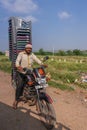 Guy on motorbike transport pile of chairs Pattadakai Karnataka India