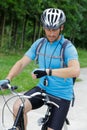 Guy on mountain bike uses cycling wacth Royalty Free Stock Photo