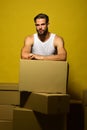 Guy with muscular hands leans on boxes.