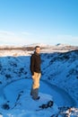 The guy near the frozen lake kerid in the crater of the volcano. Wonderful Iceland in the winter