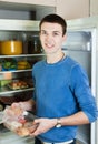 Guy near opened refrigerator in kitchen Royalty Free Stock Photo