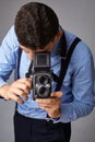 Guy with the old camera at the studio. Guy shoots on an old vintage film camera with two lenses. Royalty Free Stock Photo