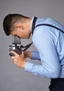 Guy with the old camera at the studio. Guy shoots on an old vintage film camera with two lenses. Royalty Free Stock Photo