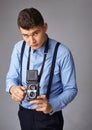 Guy with the old camera at the studio. Guy shoots on an old vintage film camera with two lenses. Royalty Free Stock Photo