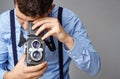 Guy with the old camera at the studio. Guy shoots on an old vintage film camera with two lenses. Royalty Free Stock Photo