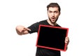 Surprised man in black t-shirt shows advertisement in studio. Guy with open mouth points finger space for your text or ad on Royalty Free Stock Photo