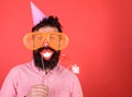 Guy in party hat celebrate, posing with photo props. Hipster in giant sunglasses celebrating. Man with beard on cheerful Royalty Free Stock Photo