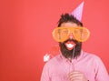 Guy in party hat celebrate, posing with photo props. Hipster in giant sunglasses celebrating. Man with beard on cheerful Royalty Free Stock Photo
