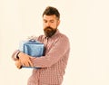 Guy in plaid shirt hugs present box. Macho with wrapped blue gift and white bow Royalty Free Stock Photo