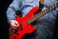 A guy in a plaid shirt with an red electric guitar stands on the recording Studio. The guitarist plays the strings of a musical Royalty Free Stock Photo