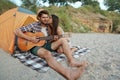 Guy play on guitar to girl who is kissing him Royalty Free Stock Photo