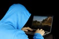 Guy in blue hoodie playing a computer game on laptop Royalty Free Stock Photo