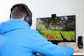 Guy in headphones playing a computer game on desktop PC Royalty Free Stock Photo