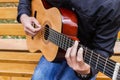 Guy playing a guitar while sitting on a bench Royalty Free Stock Photo