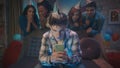 A guy is playing an online game on his phone, his friends are watching him tensely standing behind him. Games Royalty Free Stock Photo