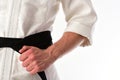 Guy poses in white kimono with black belt, close up.