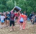 A guy pours colored water from a bucket on a girl after a water sports event at a summer camp