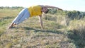 Guy practicing yoga moves and positions outdoors. Young man standing at yoga pose at nature. Athlete doing strength Royalty Free Stock Photo