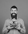 Guy presents homegrown harvest. Farmer with cheerful face holds red apples. Gardening and crops