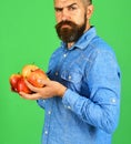 Guy presents homegrown harvest. Farmer with strict face