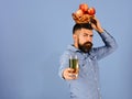 Guy presents homegrown harvest. Man with beard holds bowl of fruit and juice