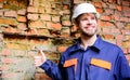 Guy protective helmet bearded handsome builder. Builder helmet construction site brick wall background. Man take break Royalty Free Stock Photo