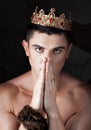 Guy put hands and prays. On head king's crown. Royalty Free Stock Photo