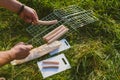 The guy puts sausages on the wire rack. Picnic in nature Royalty Free Stock Photo