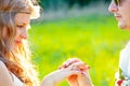 Guy putting an engagement ring on the finger of his girlfriend