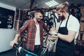 Guy and Repairman Fixes Bicycle in Sport Store