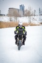A guy rides a motorcycle on a frozen lake