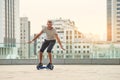 Guy riding hoverboard, city background. Royalty Free Stock Photo