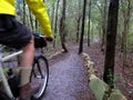 Guy riding mountain bike on wet trail. Royalty Free Stock Photo