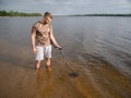 Guy in the river is looking for treasure with a metal detector in the water Royalty Free Stock Photo